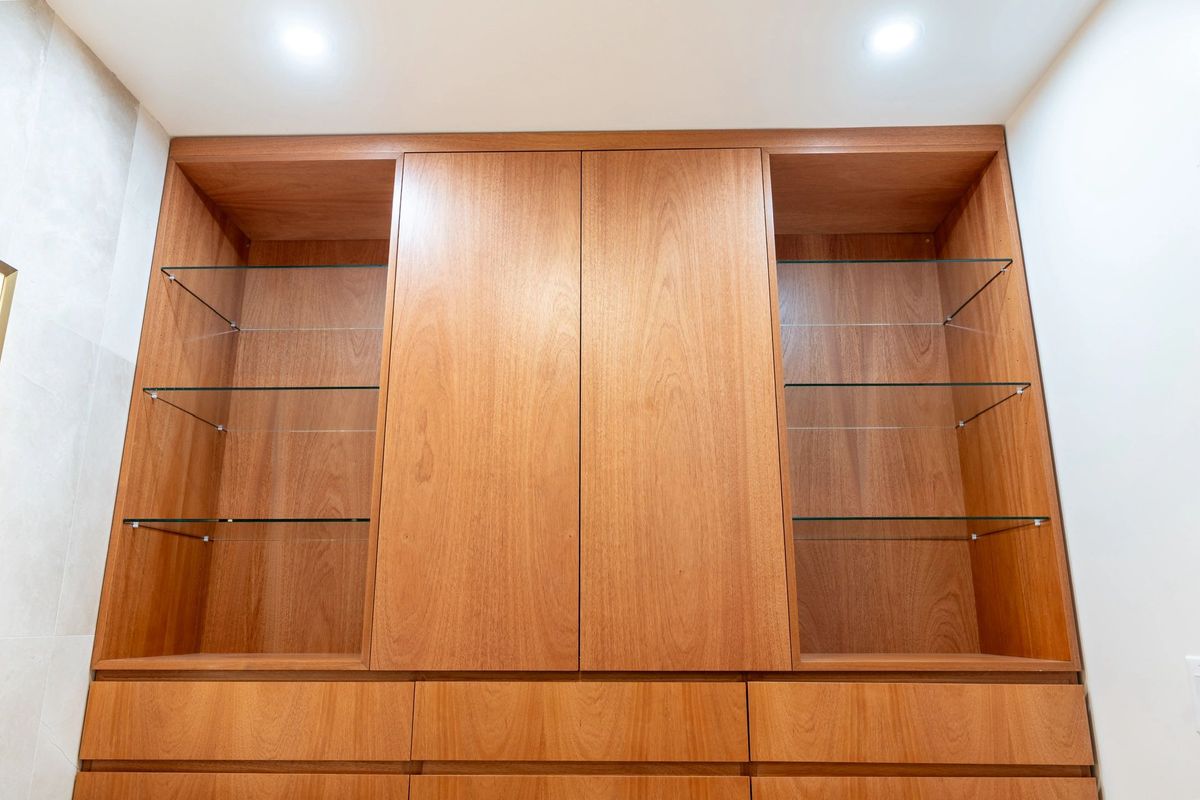 Custom cherry built in cabinetry with glass shelving